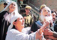 Wailing parents of a policeman are consoled by a relative at the Special Operation Groups camp.