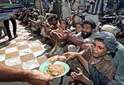 An Afghan child, who survives by collecting garbage, receives free food