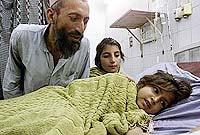 Wahid Gul comforts his 11-year-old daughter Khatoon, who is suffering from acute renal failure at a hospital in Peshawar, on Thursday.