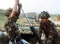 Indian soldiers clear a mortar gun after firing across the border