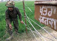 An Indian soldier crosses a fence
