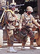 Troops carry weapons and communication equipment during the siege of a mosque