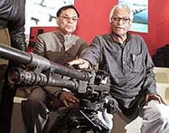 Defence Minister George Fernandes points to a tripod-mounted machine gun