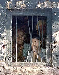 A Hindu family pleads with a nearby soldier