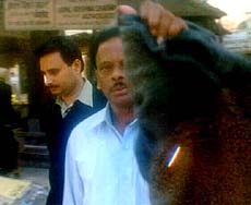 A CBI official tries to cover lenses of photographers