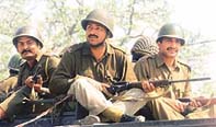 CRPF jawans sit atop a convoy while staging a flag march
