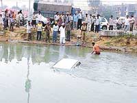 A policeman helps bring out the car out of the Sidhwan canal in Ludhiana on Saturday morning.