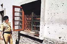 A BSF officer inspects the damage caused by a grenade explosion