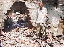 A man goes through his house which was destroyed by rioters