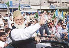 Qazi Hussain Ahmed, chief of the Jamaat-i-Islami party, waves to his supporters