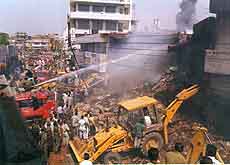 Fire tenders try to control a devastating fire which broke out after a MiG-21 crash-landed on a bank building in Jalandhar 