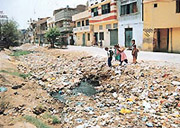 Children play on the surface of city drain which has become a dumping ground.