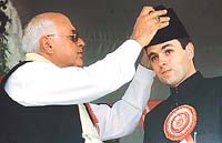 The Jammu and Kashmir Chief Minister and former President of the National Conference, Dr Farooq Abdullah (left), gives a cap to his son, Mr Omar Abdullah, after he was appointed party chief during a ceremony in Srinagar on Sunday.