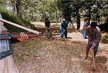 Farmers work on their land under the strict vigil of armed security personnel