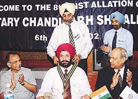 Lt-Col A.P. Singh, outgoing President, puts on the President’s Colour on Dr Kochhar, President for the year 2002-03