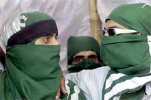 Masked supporters of the Awami National Conference attend an election rally