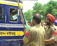 Policemen 'attack' the driver of a vehicle with lathis during a scuffle at Malout on Wednesday.