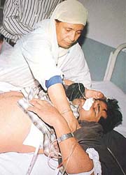 A woman para-medic attends to Tulsi Ram, an injured pilgrim, at a hospital.