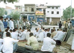 Activists of the BJP holding a dharna in front of the liquor vend
