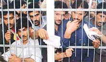 Kashmiri men wait to receive their election identification cards 