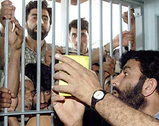 A government official shows a voter identity card to Kashmiris waiting for their cards