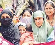 Kashmiri women listen to the speech of a National Conference leader