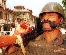 A paramilitary jawan stands guard at a sensitive area in downtown Srinagar