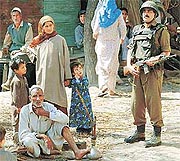 BSF personnel stand guard near a polling station