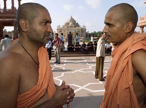 Priests talk after commandos flushed out gunmen from the complex in Gandhinagar on Wednesday