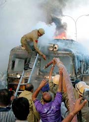 Firemen extinguish a fire following a bomb blast on a passenger bus in Jammu, on Wednesday