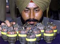 A BSF jawan examines hand grenades