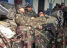 Indian soldiers rest as they wait to catch a train at Amritsar station