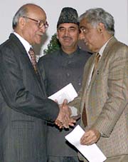 The head of the new coalition government in Kashmir, Mufti Mohammed Sayeed, shakes hands with Mr Girish Chandra Saxena, Jammu and Kashmir Governor