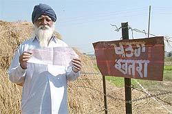Bhagel Singh of Rajatal village, the most mined area, shows the electricity bills received for tubewells situated in areas inaccessible due to the mines