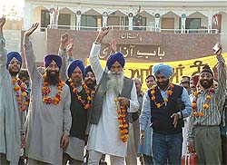 Mr Sham Singh, Co-Chairman of the PSGPC along with Sikh pilgrims from India, raise religious slogans