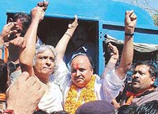 Acharya Dharmendra and Pravin Togadia raise their arms with other VHP activists after being detained by the police in Ahmedabad 