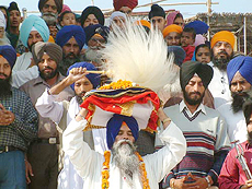Giani Puran Singh, Head Granthi, Darbar Sahib, carries Guru Granth Sahib on his head as he comes out of Akal Takht Sahib during nagar kirtan on the eve of the 533rd birth anniversary of Sri Guru Nanak Dev in Amritsar 