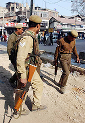 CRPF personnel look at the blood-stained road near their camp at Regal Chowk in Srinaga