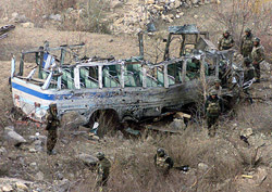 Army jawans inspect the wreckage of a bus after a landmine explosion at Lower Munda, 90 km south of Srinagar, on Saturday.