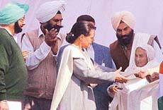 Ms Sonia Gandhi honours Ms Gurdial Kaur, wife of Subedar (Honorary Captain) Joginder Singh, at an ex-servicemens rally in Chandigarh on Saturday.