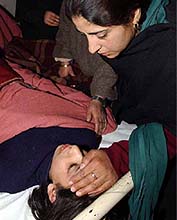 A relative of Nazia Ayoub attends to her at a local hospital in Srinagar 
