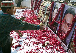A boy showers rose petals on portraits of security officers killed in last years attack on Parliament 