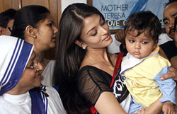 Bollywood star and former Miss World Aishwarya Rai carries an orphan child as a nun looks on