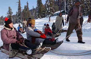 A group of domestic tourists enjoys sledge rides at Gulmarg in North Kashmir on Sunday.
