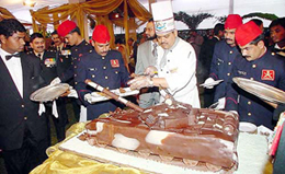 Guests enjoy a cake in the shape of a tank at the Army chiefs At Home on the occasion of Army Day 