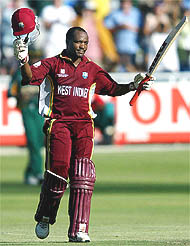 Brian Lara of the West Indies raises his bat to acknowledge the cheering crowd
