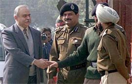 Acting Indian High Commissioner to Pakistan Sudhir Vyas shakes hands with Indian officials after crossing into India on the Wagah border