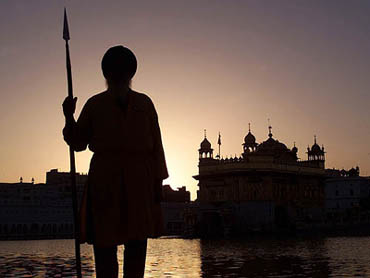 A Sikh temple worker stands guard inside the Golden Temple complex