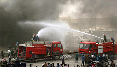 Iraqi fire-fighters douse flames in a building