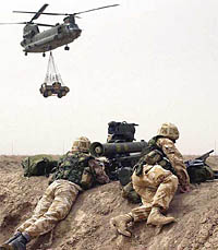 British Royal Marines from 40 Commando man a Milan anti-tank weapon system while a Chinook helicopter transports a vehicle overhead, on the Al Faw peninsula, southern Iraq, in this photo made available 